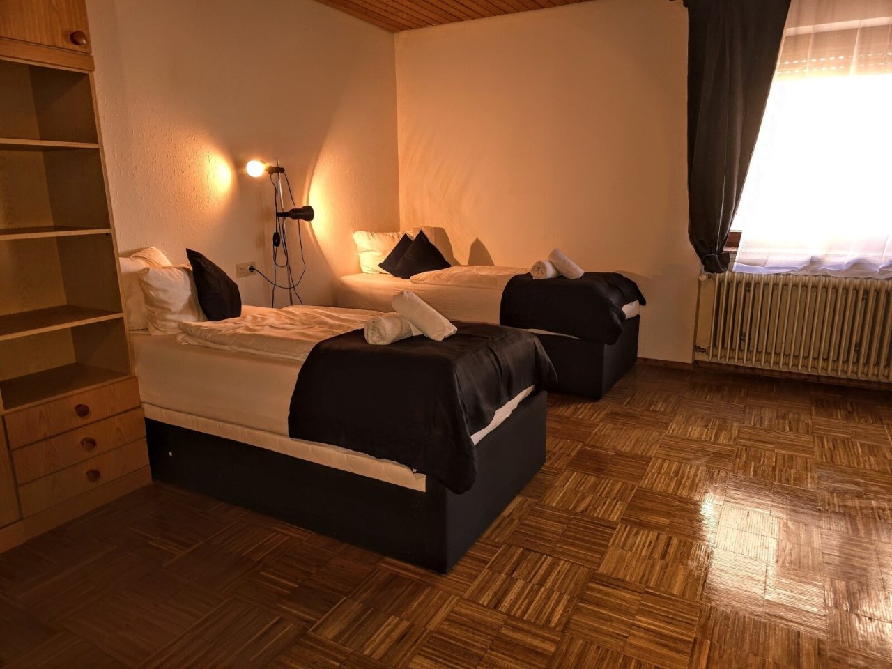 Komfortables Zweibettzimmer mit integriertem Stauraum und warmem Lichtambiente