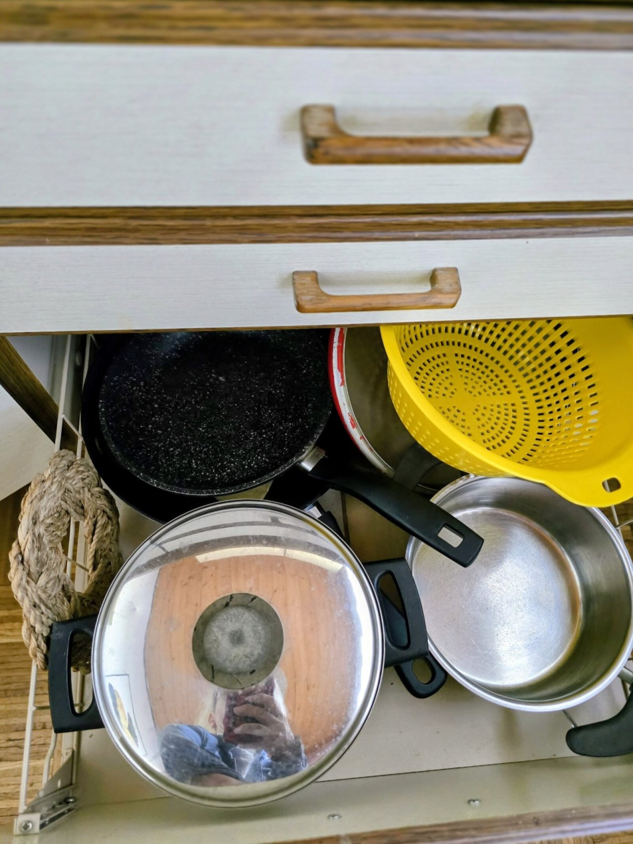 Умная организация кухни: многофункциональный ящик с продуманным решением для хранения сковород и сит.